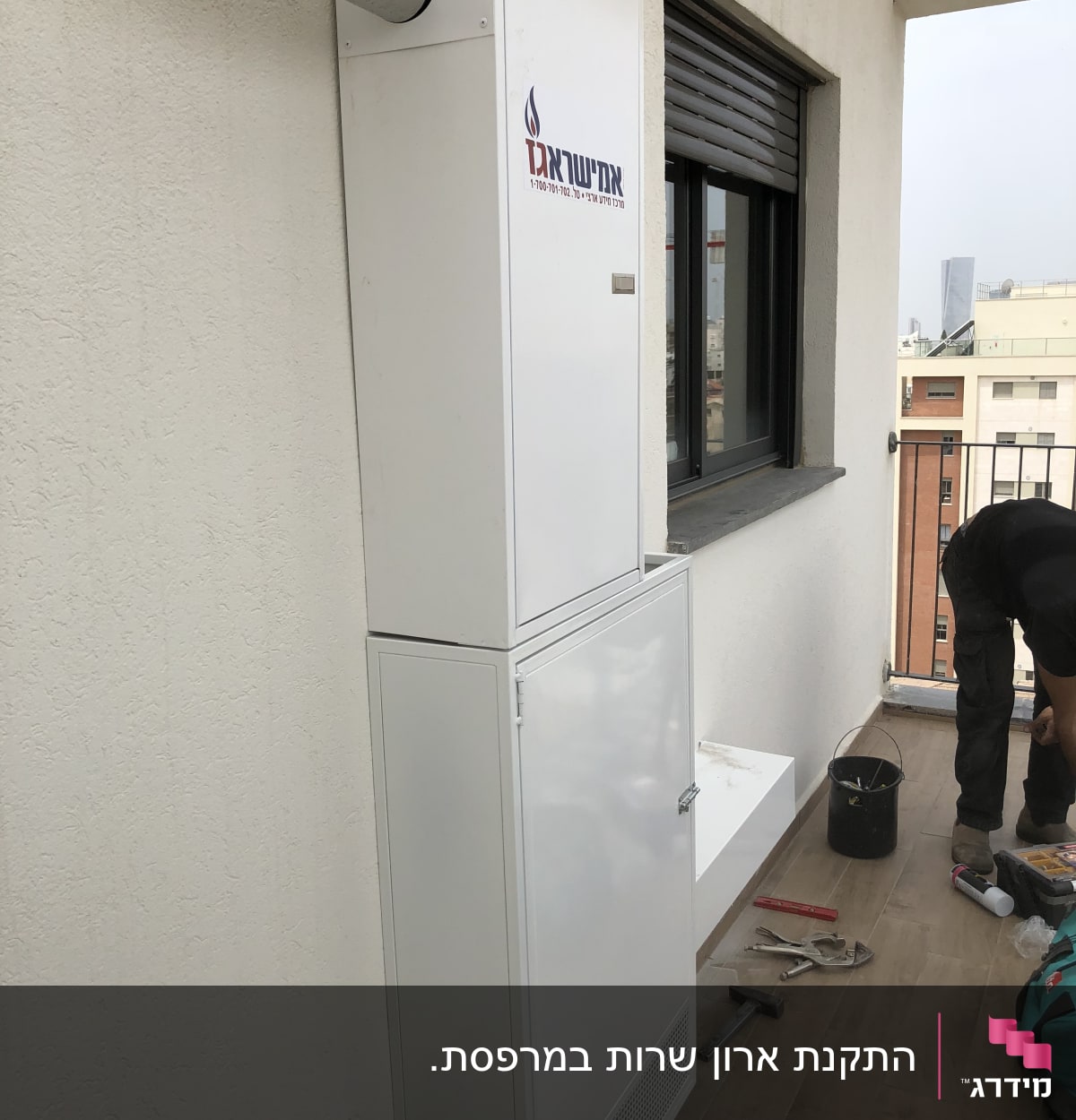 ארון מתכת לבן עם צינור פליטה מותקן על קיר